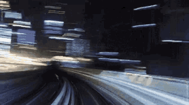 a blurry picture of a train going down a track