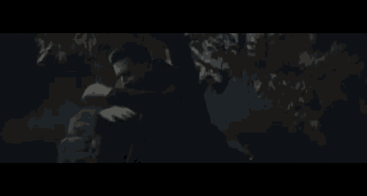 a man in a black coat is standing in the dark .