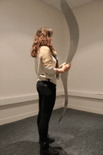 a woman standing in a room holding a piece of paper
