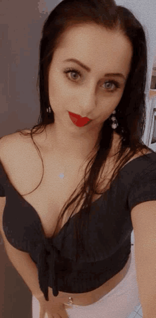 a woman wearing a black off the shoulder top and white shorts