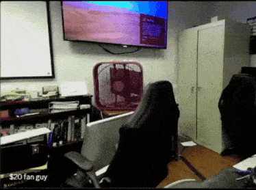 a fan is sitting in front of a flat screen tv that says $ 20 fan guy on the bottom