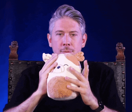 a man is holding a stuffed animal in his hands