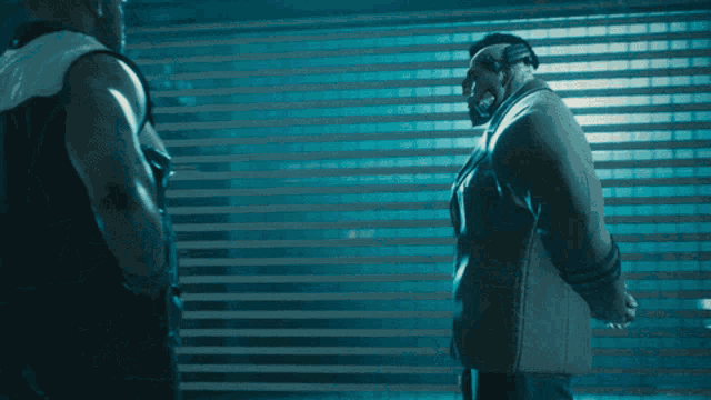 a man in a suit shakes hands with a man in a white jacket