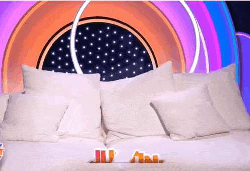 a couch with white pillows and the word ju on the bottom right