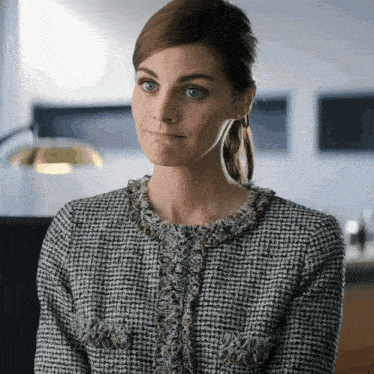 a woman wearing a black and white sweater makes a silly face
