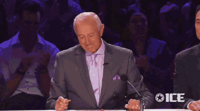 a man in a purple suit is standing next to a woman in a purple dress and the word ice is on the bottom right