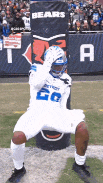 a football player in a detroit uniform is kneeling on the field