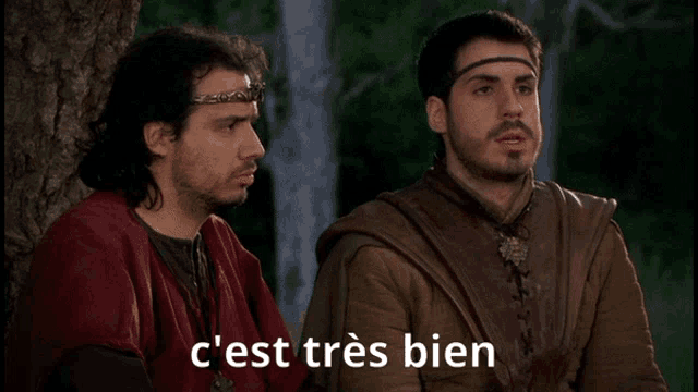 two men are sitting next to each other with the caption c'est tres bien