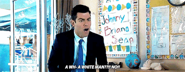 a man in a suit and tie is standing in front of a sign that says johnny briand