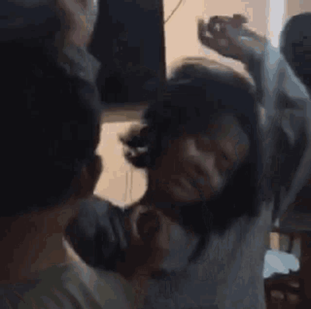 a group of people are dancing in a room with their hands in the air .