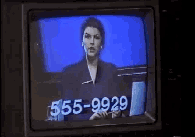 a woman is talking on a television screen with the number 555-9928 on the screen .