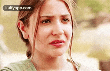 a close up of a woman 's face with a tear coming out of her eye .
