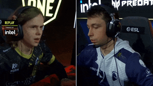 a man wearing headphones sits next to another man wearing headphones with intel written on them