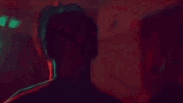 a close up of a person 's face in a dark room with a blurred background .