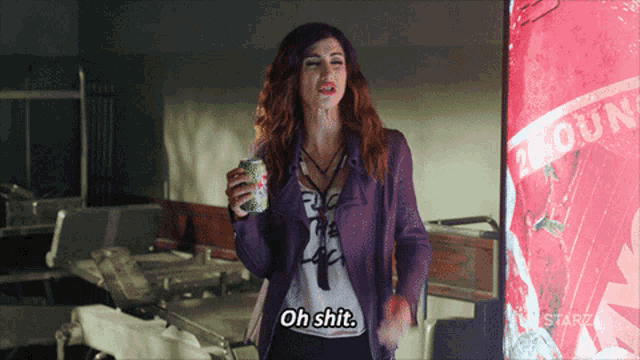 a woman in a purple jacket is holding a soda can and saying oh shit