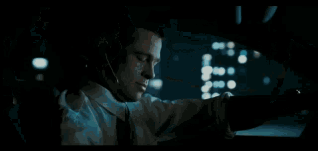 a man wearing a headset while driving a car