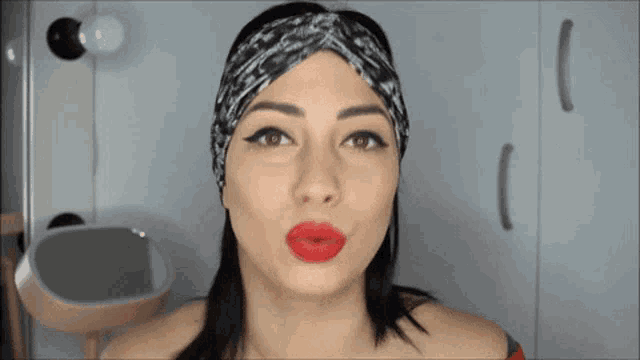 a woman wearing a headband and red lipstick is saying duture