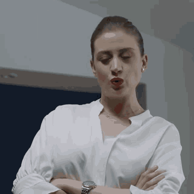 a woman with red lipstick and a watch on her wrist is making a funny face