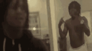 a shirtless man is taking a picture of himself in a mirror .
