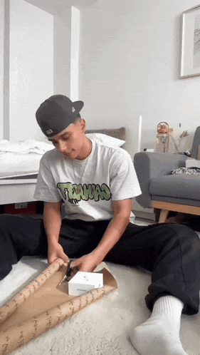 a man wearing a t-shirt that says ' texas ' is sitting on the floor