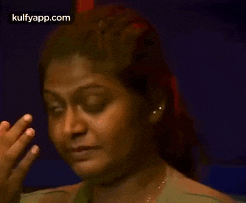 a woman is covering her nose with her hand while making a funny face .