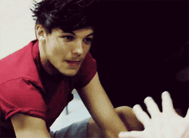 a man in a red shirt reaches out his hand