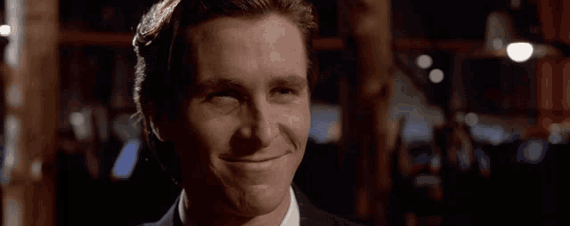 a man in a suit and white shirt is smiling