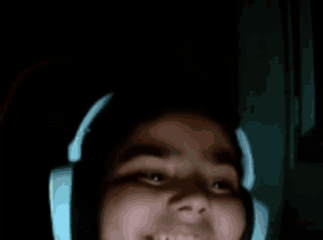 a close up of a person wearing headphones in the dark