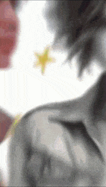 a blurry picture of a person 's back with a yellow star in the background