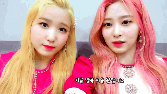 two girls with pink hair are standing next to each other with korean writing on the bottom