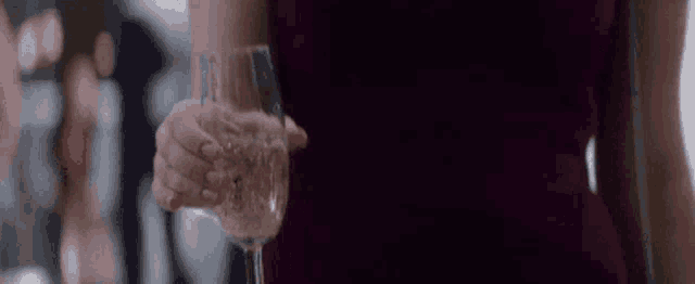 a woman in a red dress is holding a glass of champagne