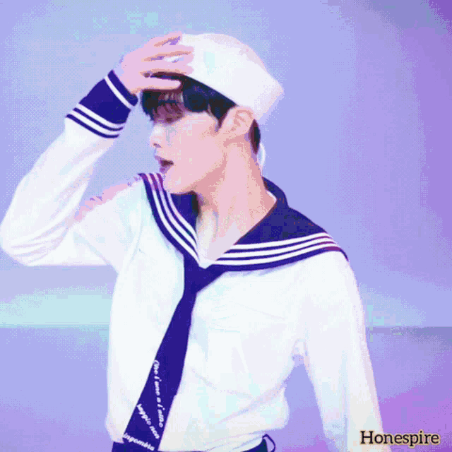 a man wearing a sailor 's uniform with the word hone spire on the bottom right