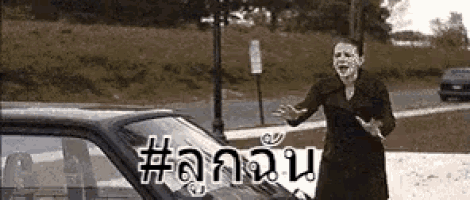 a woman with a mask on her face is standing next to a car with the word # on it .