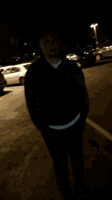 a man in a parking lot is holding a stack of money and says " show me the money "