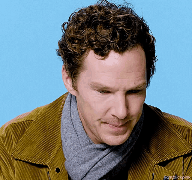 a man with curly hair is wearing a scarf and a jacket with the hashtag lightblickpink