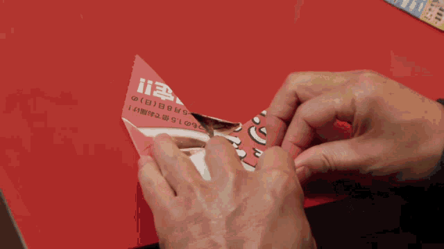 a person is folding a piece of paper that says 15 on it