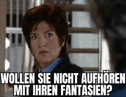 a woman in a blue shirt is standing in front of a staircase and making a funny face with a caption .