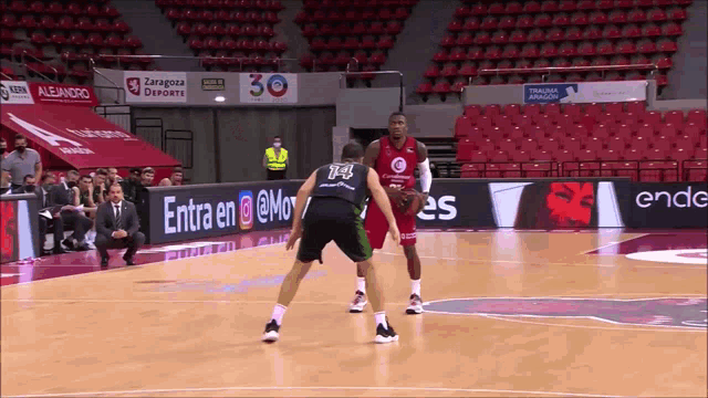 two basketball players on a court with a sign that says entra en