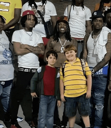 a group of young men are posing for a photo and one of them has a ny hat on