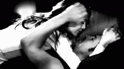 a man and a woman are kissing in a black and white photo .