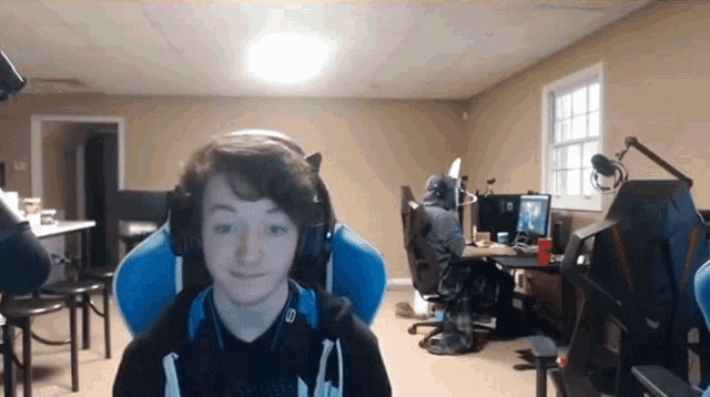 a young boy wearing headphones is sitting in a blue chair in a room .