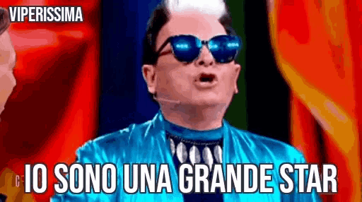 a man wearing sunglasses and a blue jacket says io sono una grande star .