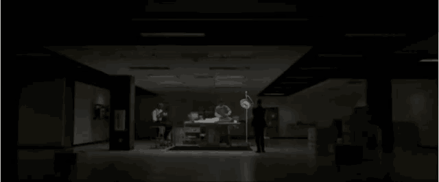 a man is standing in a dark room with boxes on the floor and a sign that says ' ambulance ' on it