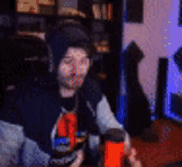 a man wearing headphones and a hat is sitting at a table in front of a microphone .