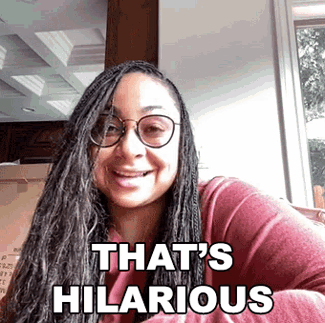 a woman wearing glasses is smiling with the words that 's hilarious below her