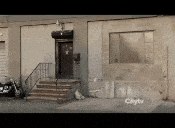 a motorcycle is parked in front of a building that says citytv on the bottom right