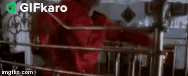 a man in a red jacket is standing in front of a machine in a room .