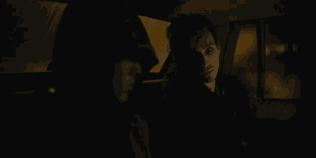 a man is sitting in a dark car with another man