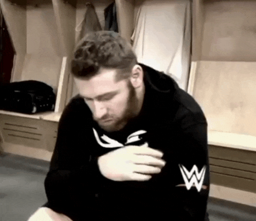 a man wearing a black sweatshirt with a w on the arm