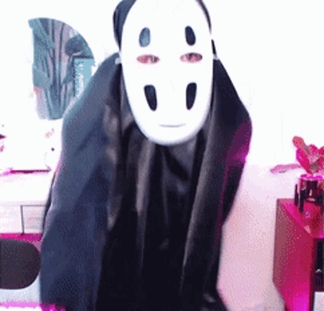 a person wearing a white mask and a black coat